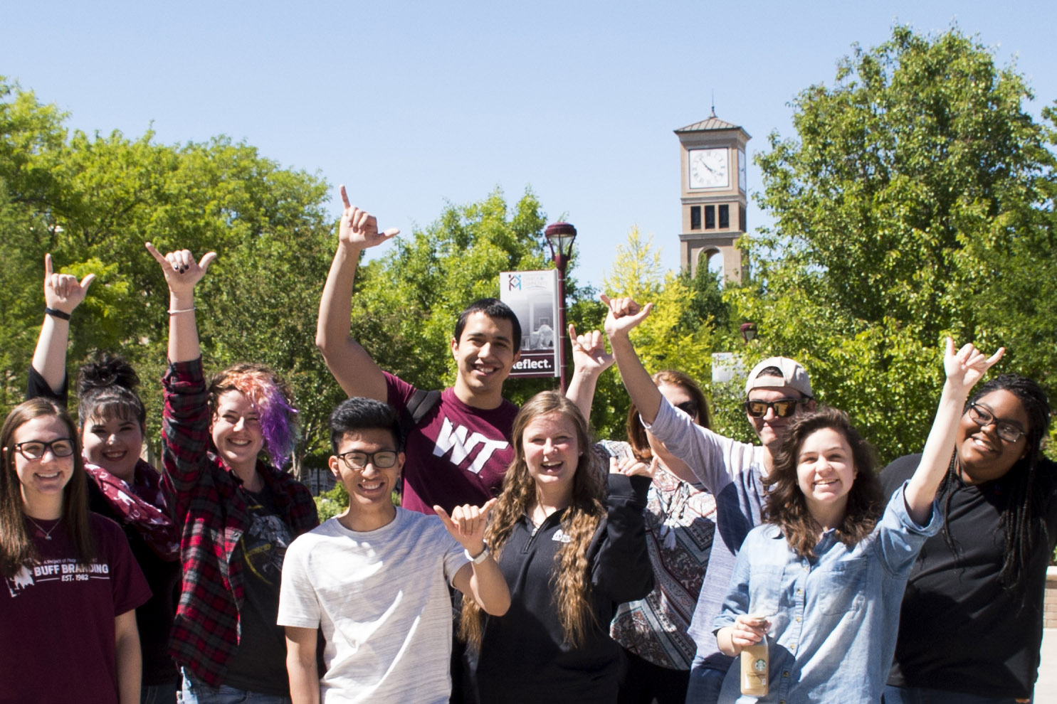 Group of students doing go buffs hand sign